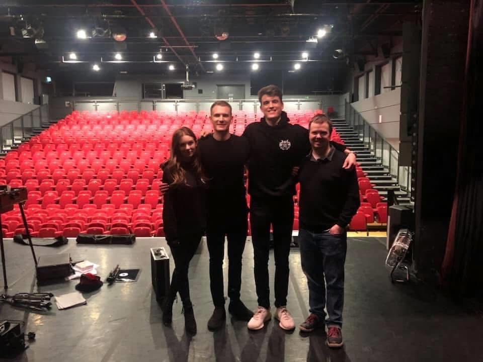 George Berryman on stage standing for a photo with attendees before or after a performance.