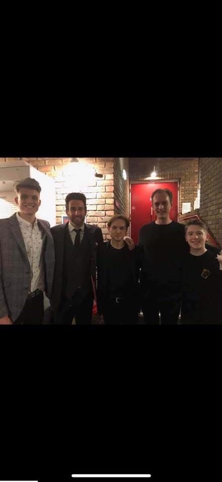 George Berryman standing backstage with other magicians after a show.