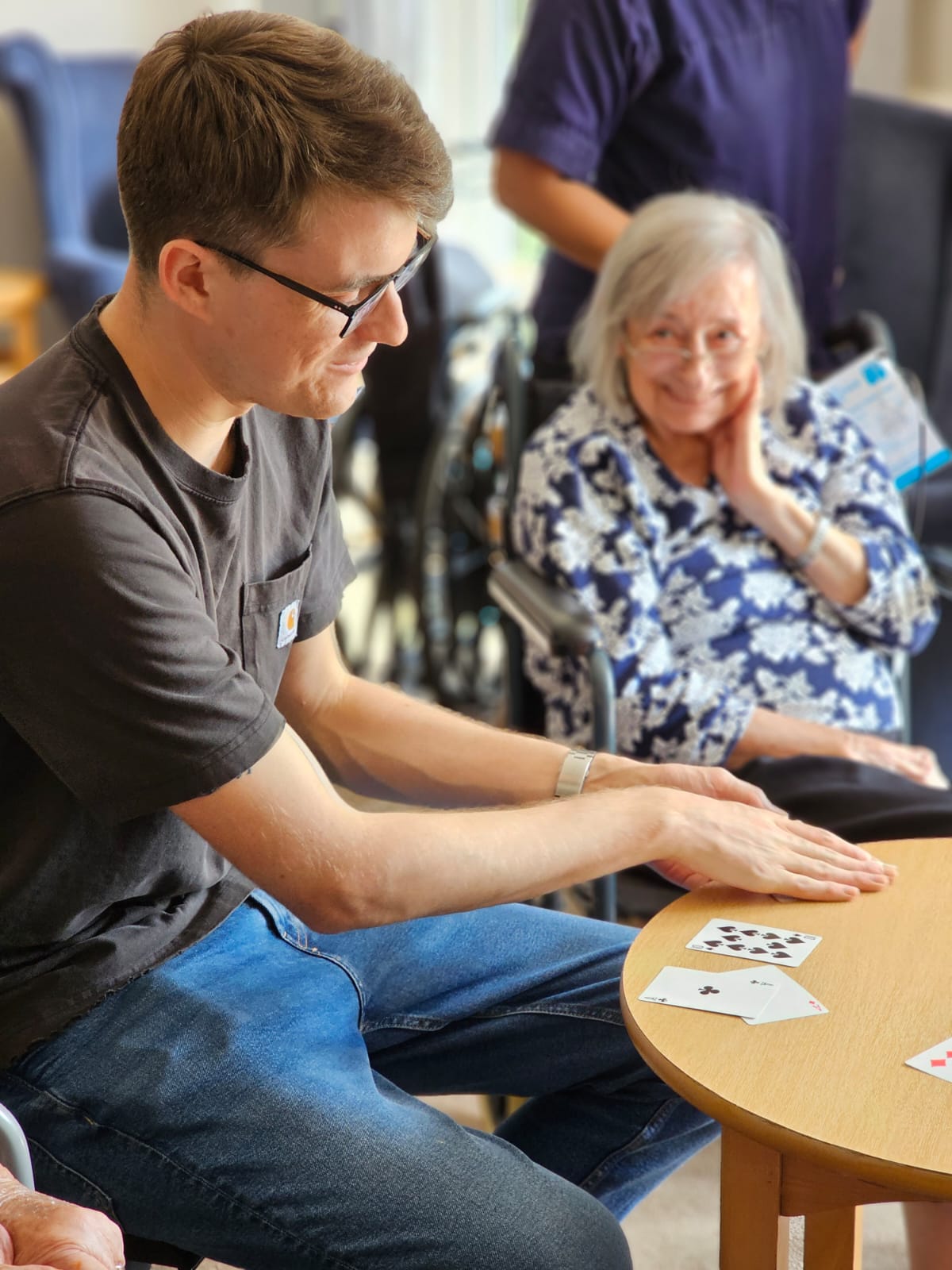 George Berryman performing at a table for elderly residents in a care home setting.